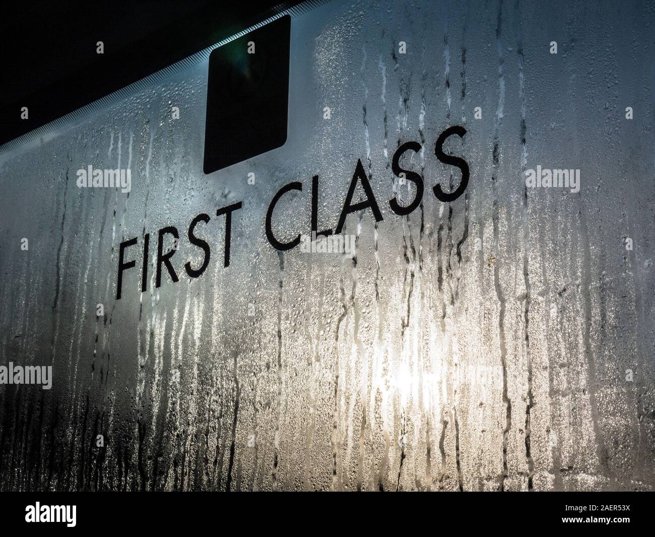 Primo treno di classe finestra Carrello segno concetto invernale con condensazione in inverno con bassa illuminazione sun umide gocce di umidità Foto Stock