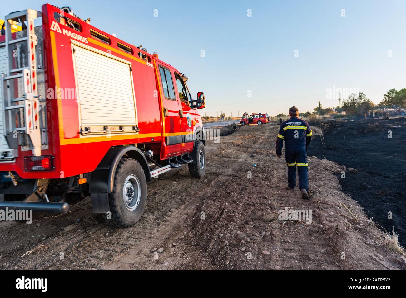 I membri dei vigili del fuoco di controllare la zona dopo il fuoco dichiarato vicino a Caceres Foto Stock