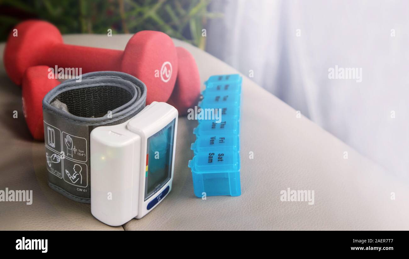 Una coppia di pesi (luce), un dosette, ed una elettronica di pressione sanguigna periferica. Foto Stock