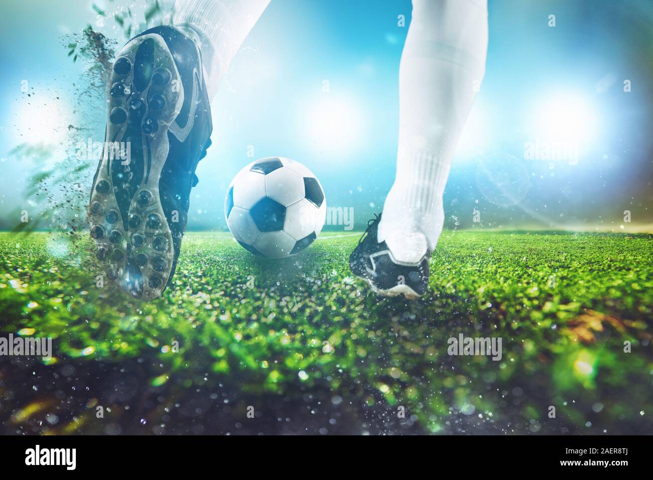 Il calcio di scena a notte corrispondono con close up di una scarpa da calcio di colpire la palla Foto Stock