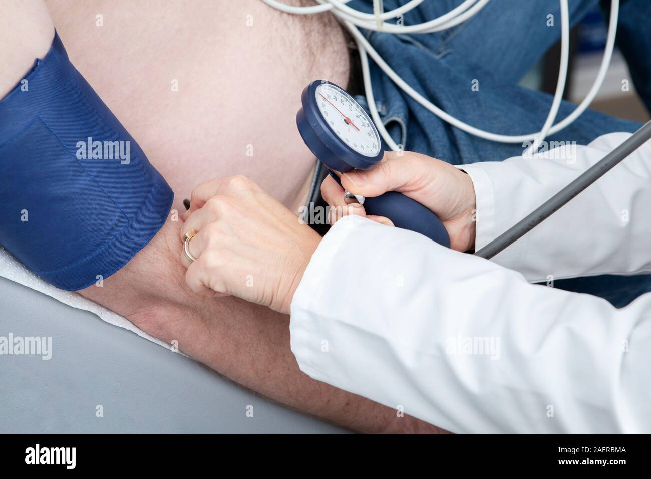Cardiologo monitora la pressione del sangue del paziente durante la cardiologia strees test. Foto Stock