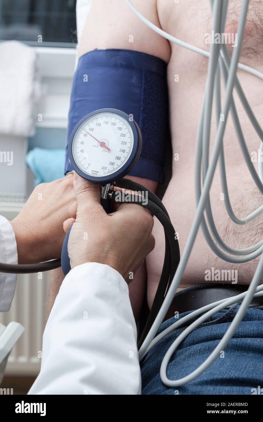 Cardiollogist monitora la pressione del sangue del paziente durante la cardiologia strees test. Foto Stock