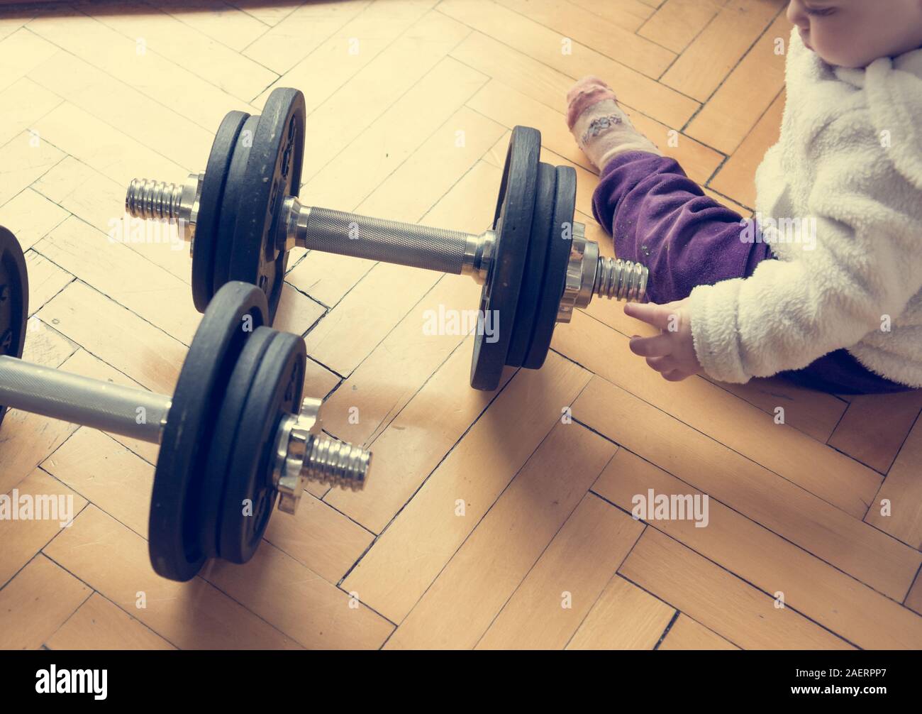 Elenco a discesa vista di un bambino che gioca con un set di barbells. Foto Stock