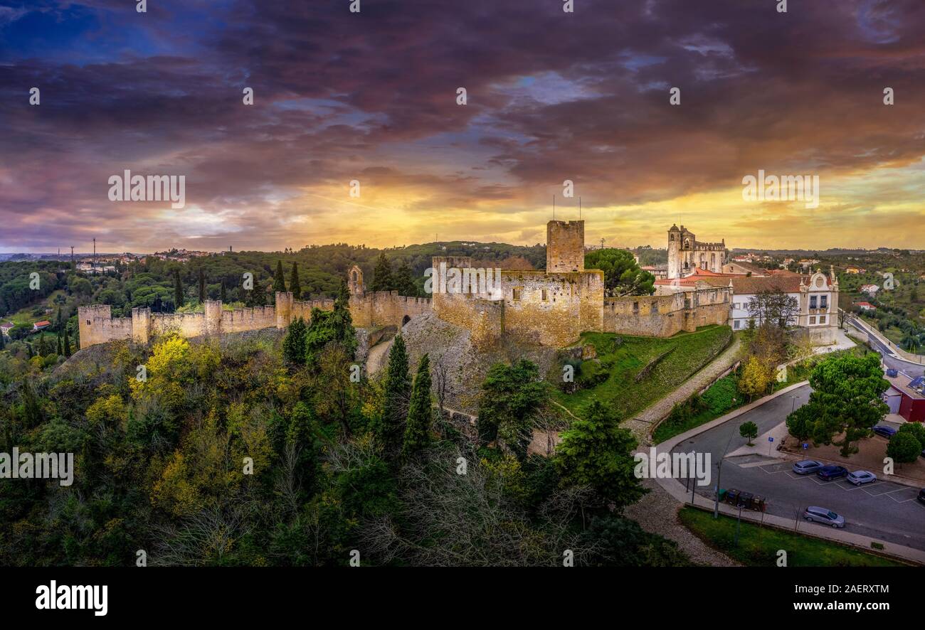 Vista aerea della città di Tomar in Portogallo con tetti rossi, Convento di Cristo roccaforte dei cavalieri templari con drammatica tempestoso Cielo di tramonto Foto Stock