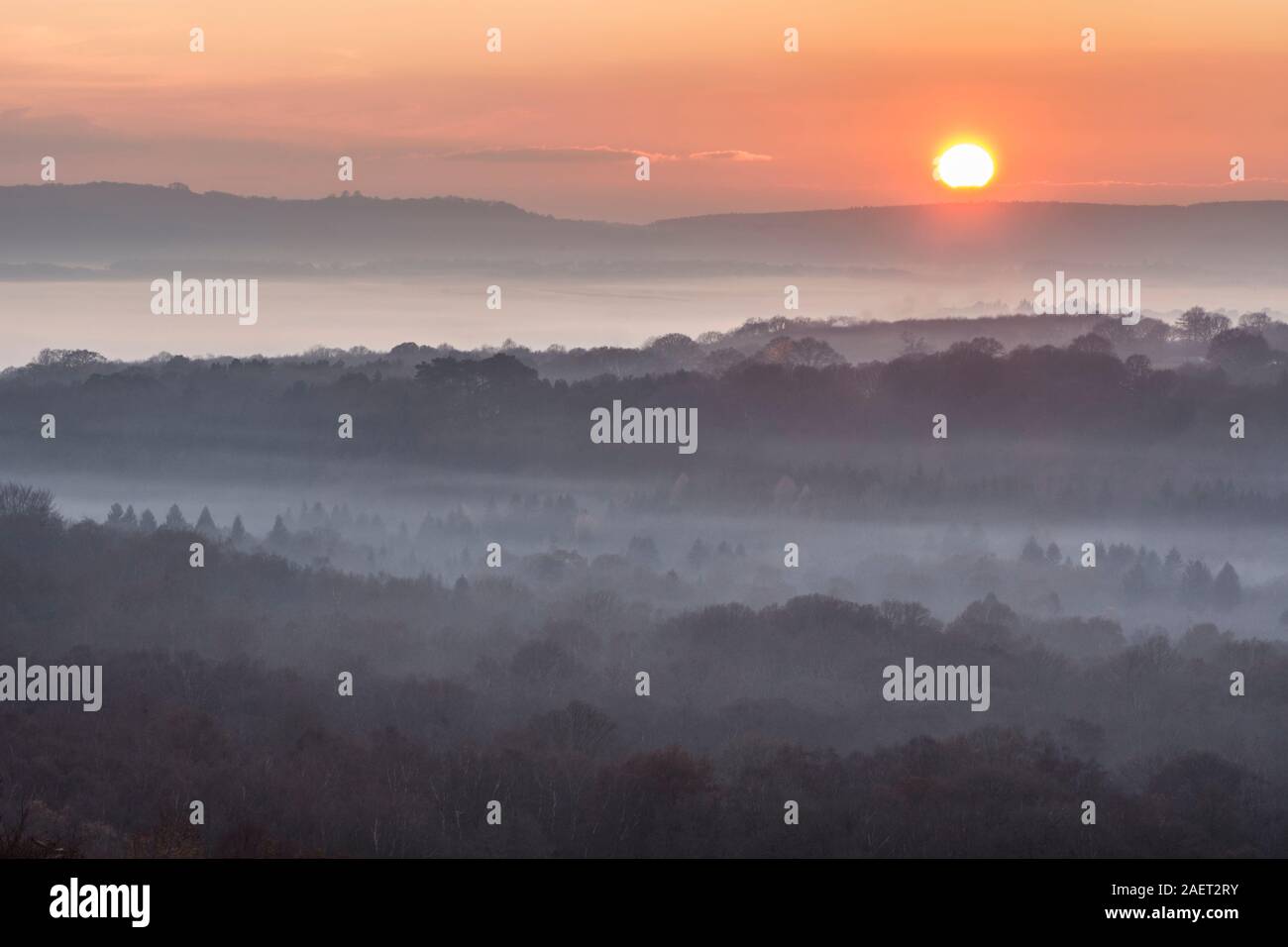 Tramonto da vecchi vista collina su nebbia bassa, Woolbeding comune e il Rother valley al South Downs, Sussex, Regno Unito, dicembre Foto Stock