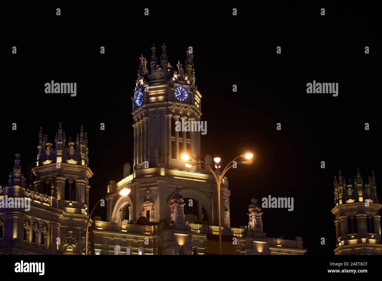 La torre dell'orologio del Palazzo delle comunicazioni a Cibeles a Madrid, illuminato in diversi colori per il Natale 2019 Foto Stock