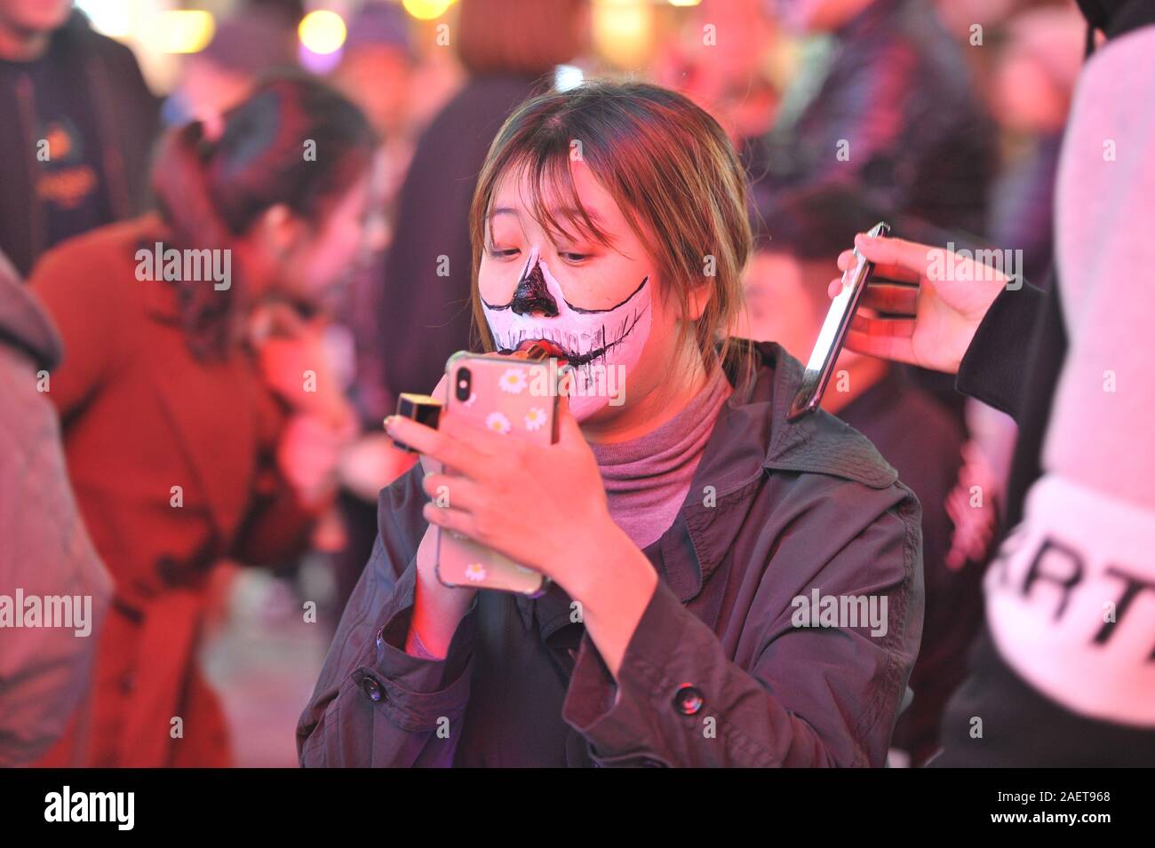 Una persona mette il rossetto utilizzando il suo telefono in una strada a Shenyang City, a nord-est della Cina di provincia di Liaoning, 31 ottobre 2019. Foto Stock