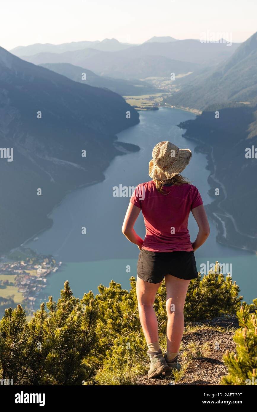 Giovane escursionista, donna guardando in lontananza, vista da Baerenkopf montagna al lago di Achen, sinistra e Seebergspitze Seekarspitze, destra Rofan Foto Stock