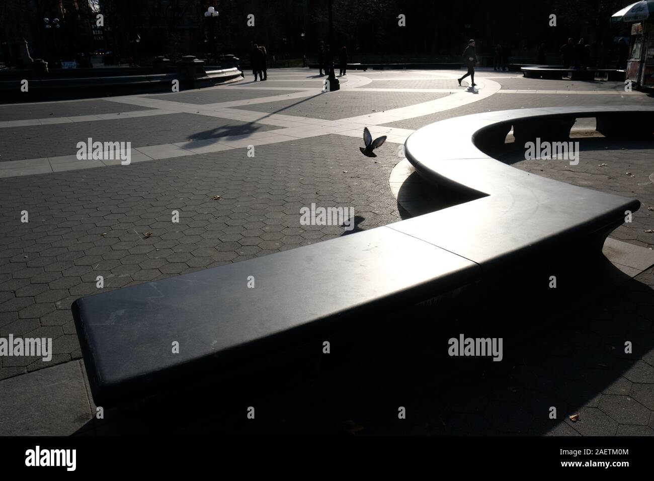 I pedoni a piedi attraverso Washington Square, NYC, in inverno la luce. Foto Stock