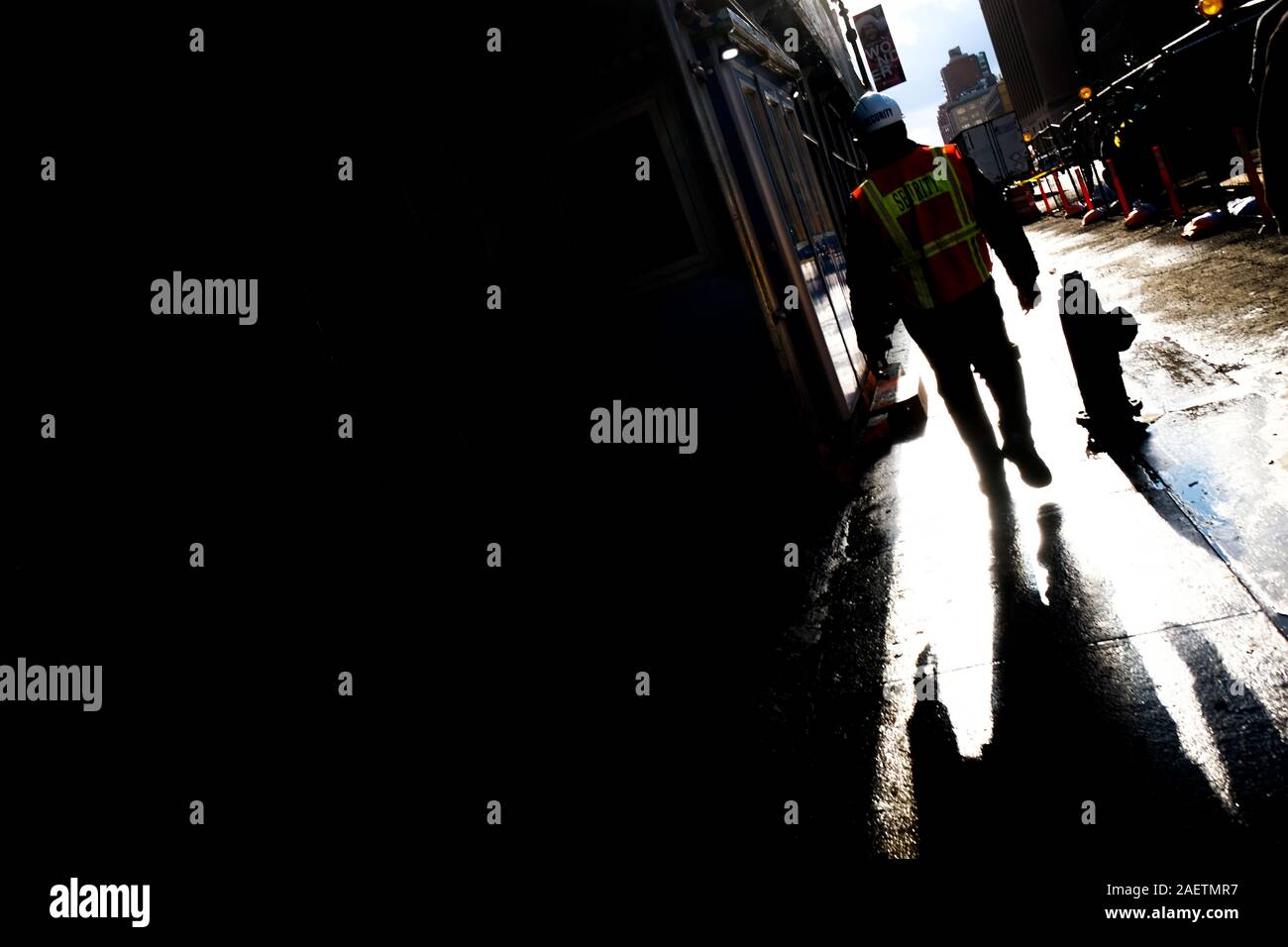 Uomo giubbotto di sicurezza passeggiate sulla 9th Avenue, New York City. Foto Stock