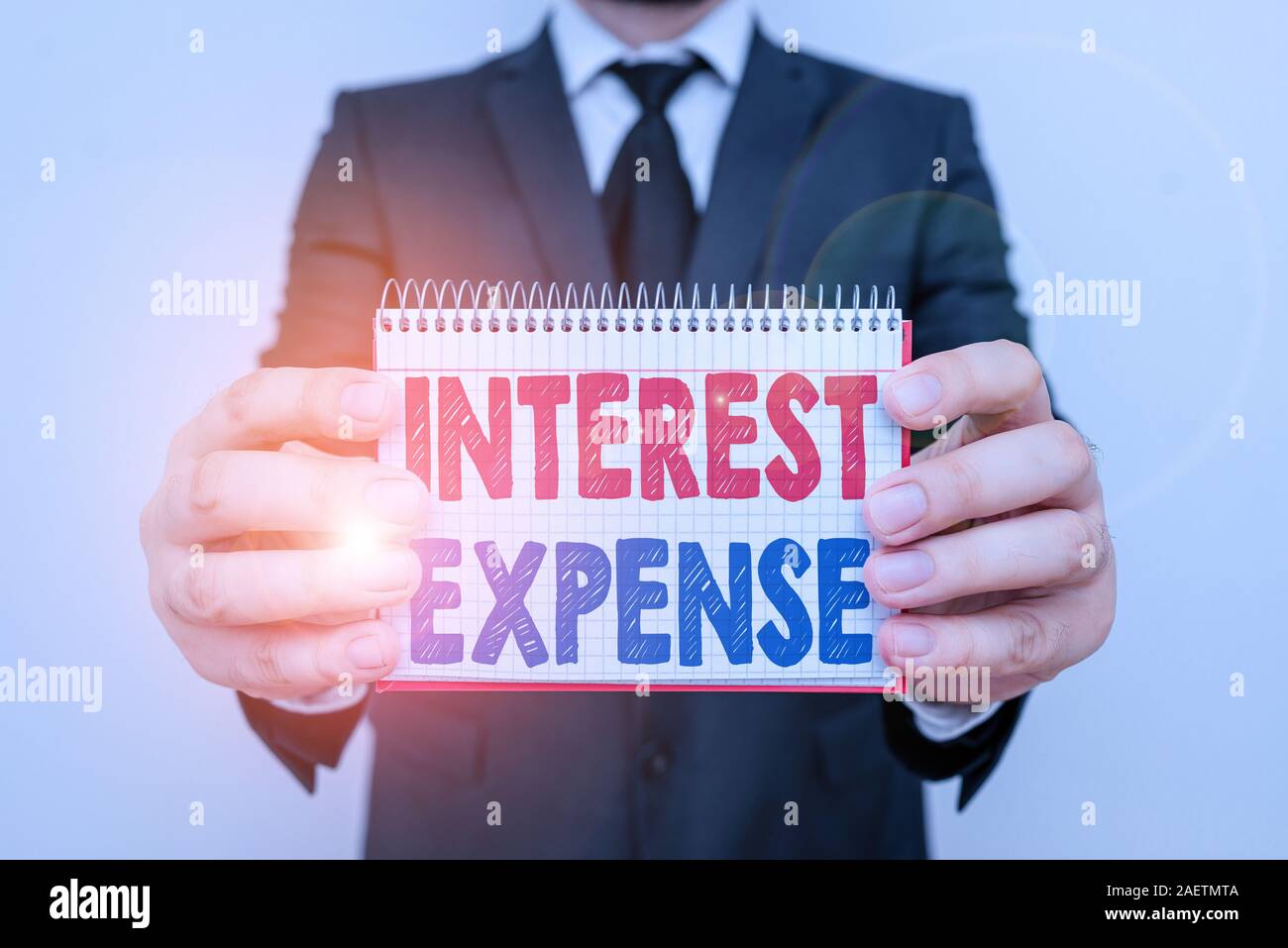 La scrittura della nota mostra interessi passivi. Il concetto di business per il costo del debito che si è verificato durante un periodo di tempo umano maschio formale indossare tuta di lavoro wi Foto Stock