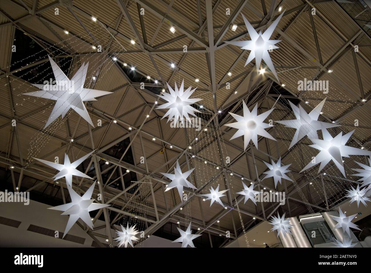 Tre dimensioni stelle bianche decorazioni natalizie appese al soffitto all'interno del centro commerciale di Cashopping Foto Stock