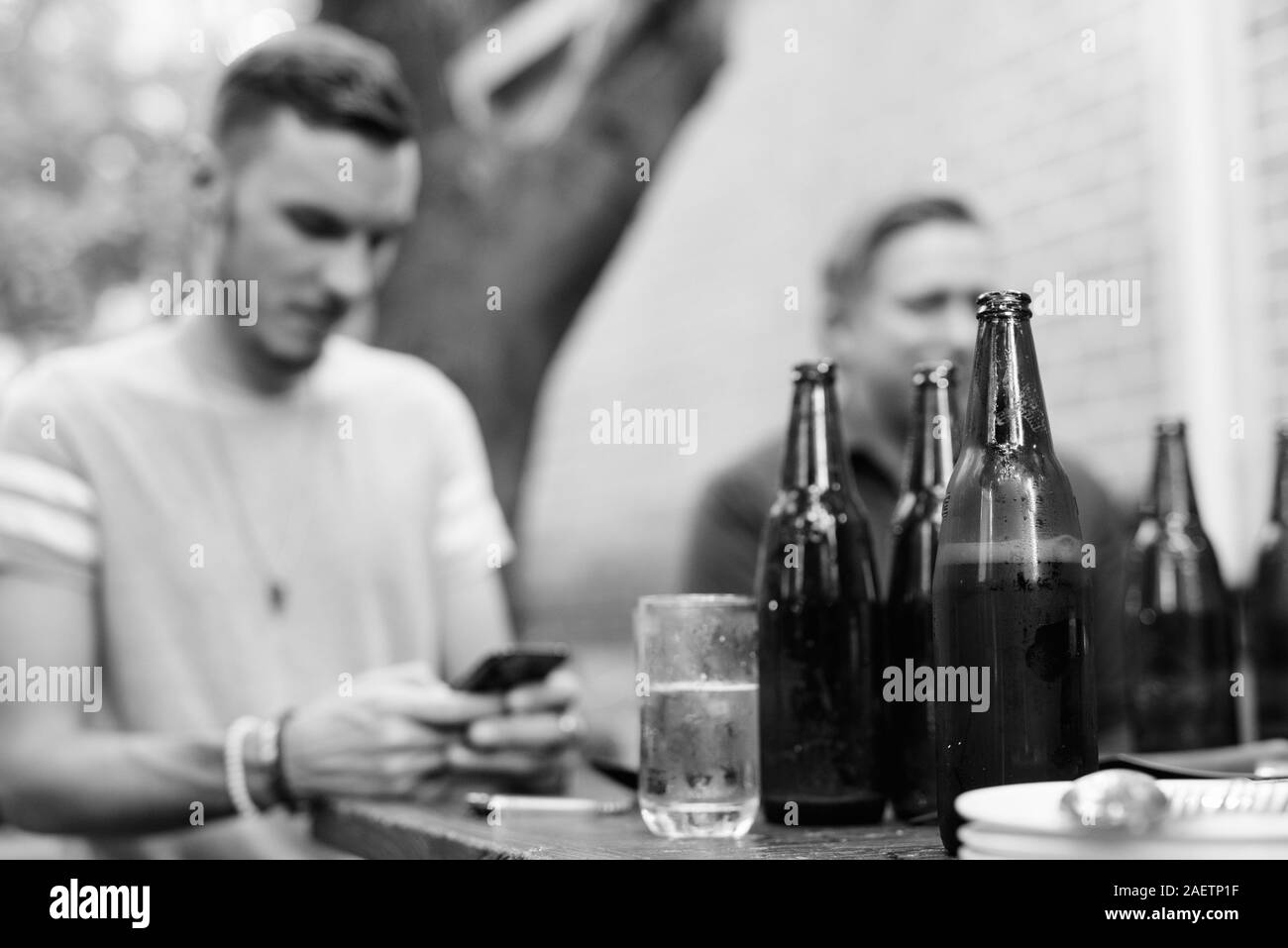 Le bottiglie di birra con uomo a bere con gli amici come appendere fuori concept Foto Stock