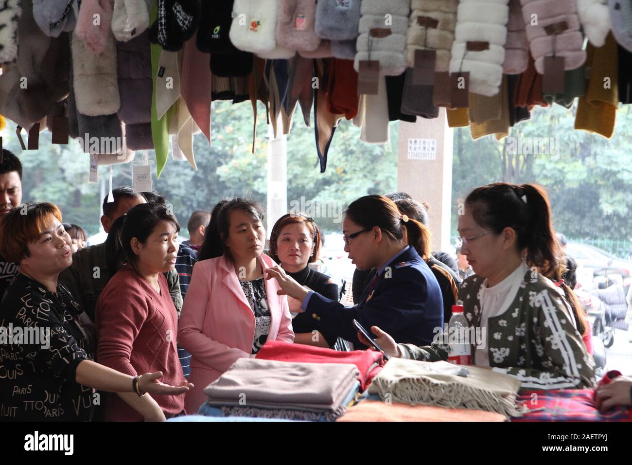 Un ufficiale parla di fornitori in un negozio di Hangzhou, a est della Cina di provincia dello Zhejiang, 7 novembre 2019. 379 prodotti contraffatti sono stati confiscati a Foto Stock