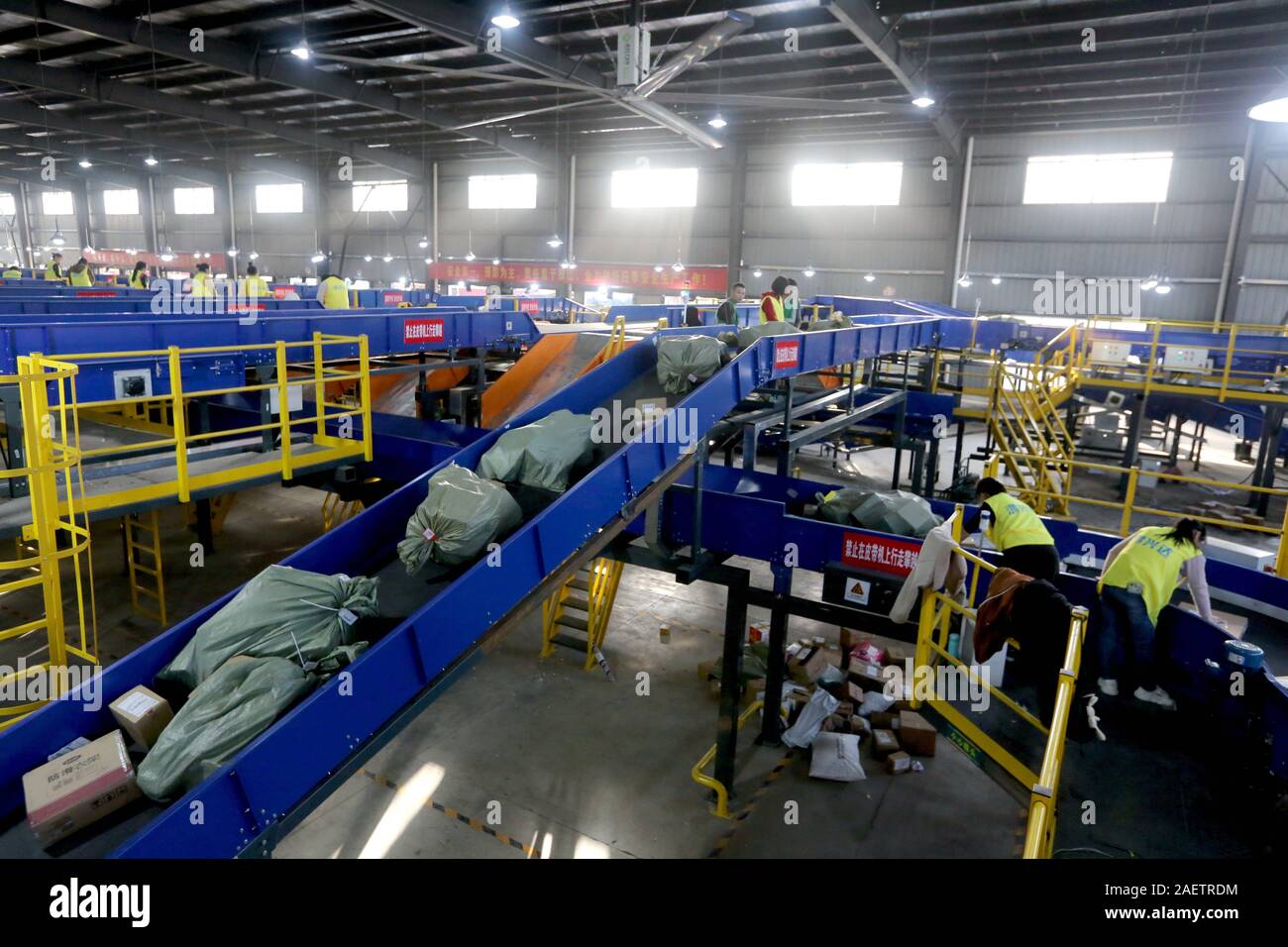 Lavoratori a EMS (Express Mail Service) centro logistico di riordinare i pacchi come doppio 11 picchi di erogazione in Huai'an City, est della Cina di provincia dello Jiangsu Foto Stock