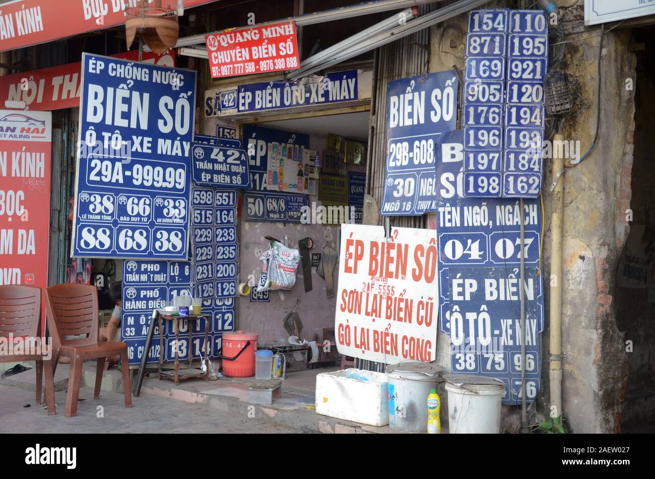 Segni al di fuori di una targa e indirizzo del negozio di segno nel quartiere vecchio di Hanoi, Vietnam Foto Stock
