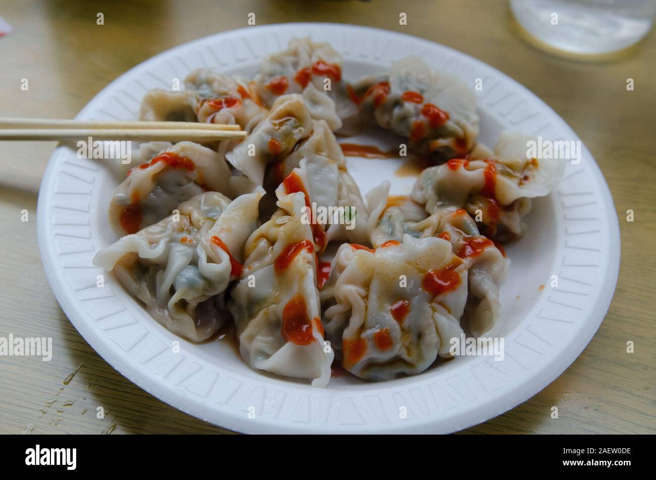 Gnocchi di patate con salsa calda e bastoncini su una piastra in polistirolo espanso in un piccolo ristorante a Chinatown, Manhattan New York City Foto Stock