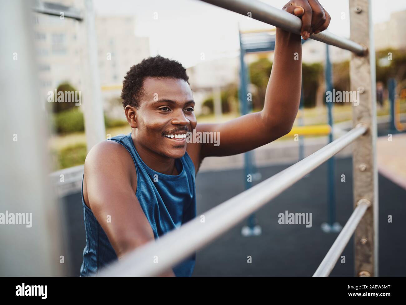 Ritratto di un giovane sorridente uomo fitness relax dopo la formazione su palestra esterna park Foto Stock