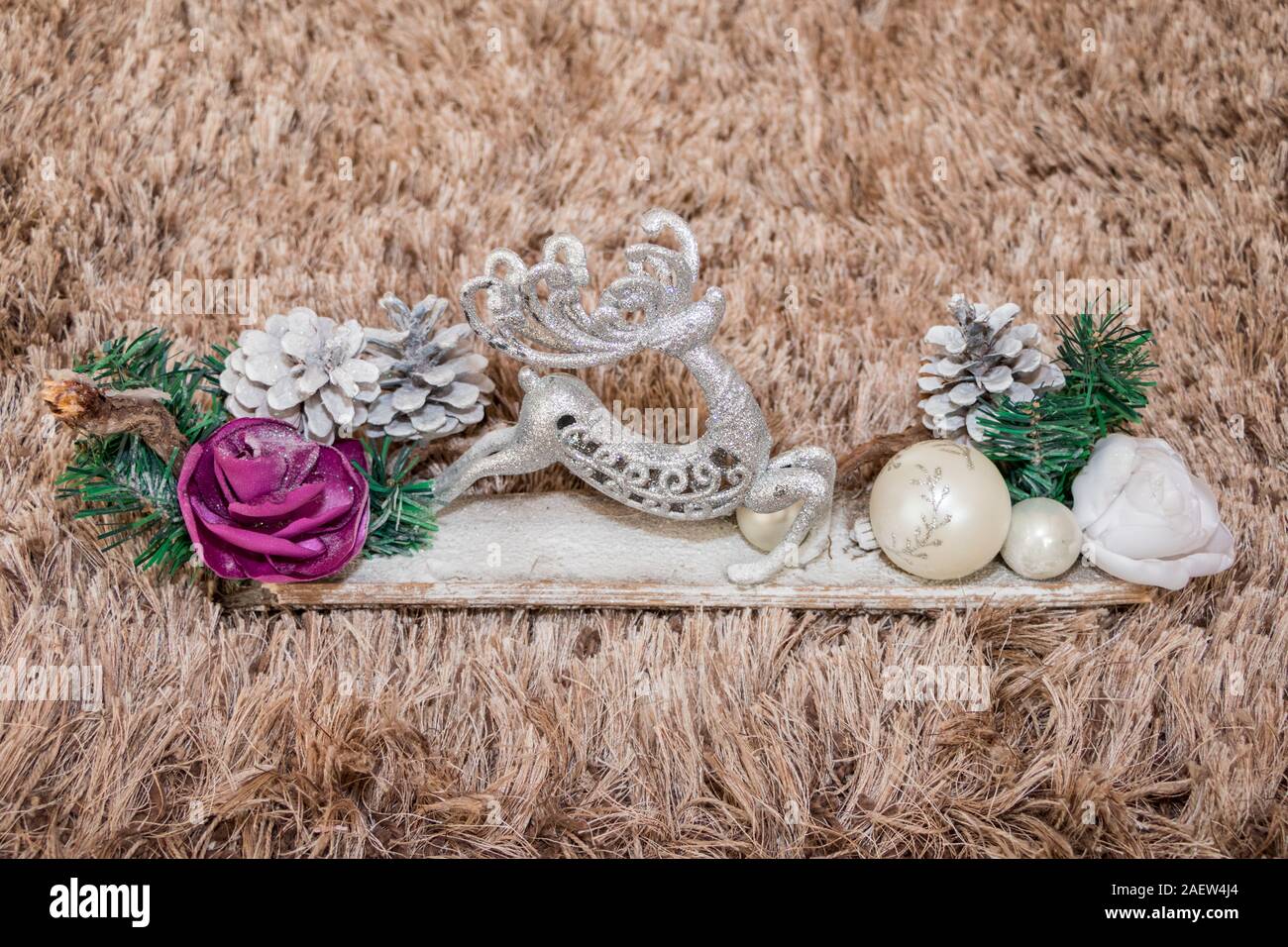 Decorazione di natale. Cervi, pigne, aghi e vacanze ornamento vicino sul tappeto marrone sfondo Foto Stock