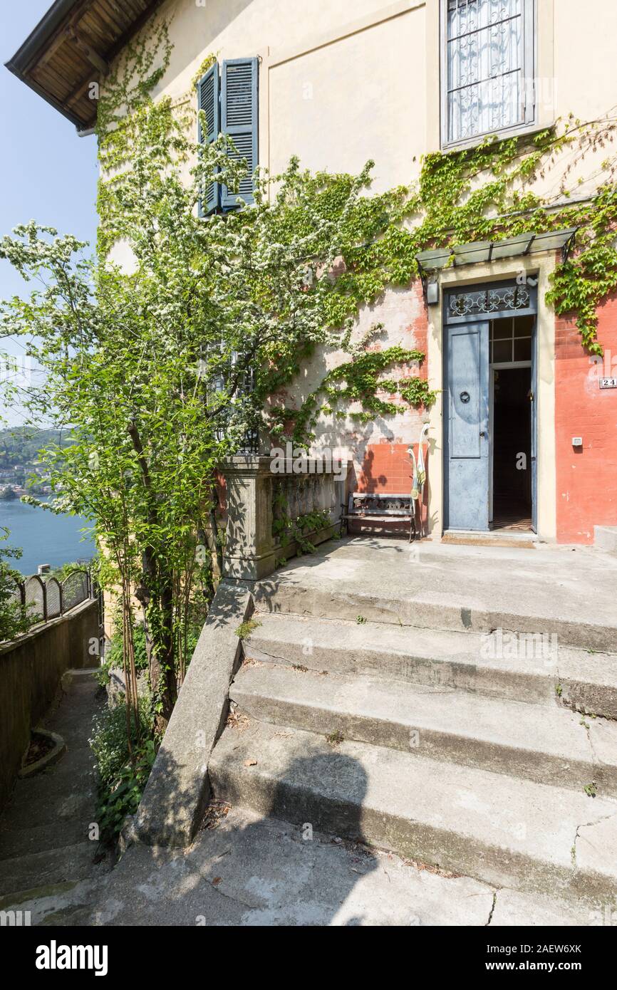 Ingresso di una casa antica, molto colorato con molte piante rampicanti. Foto Stock