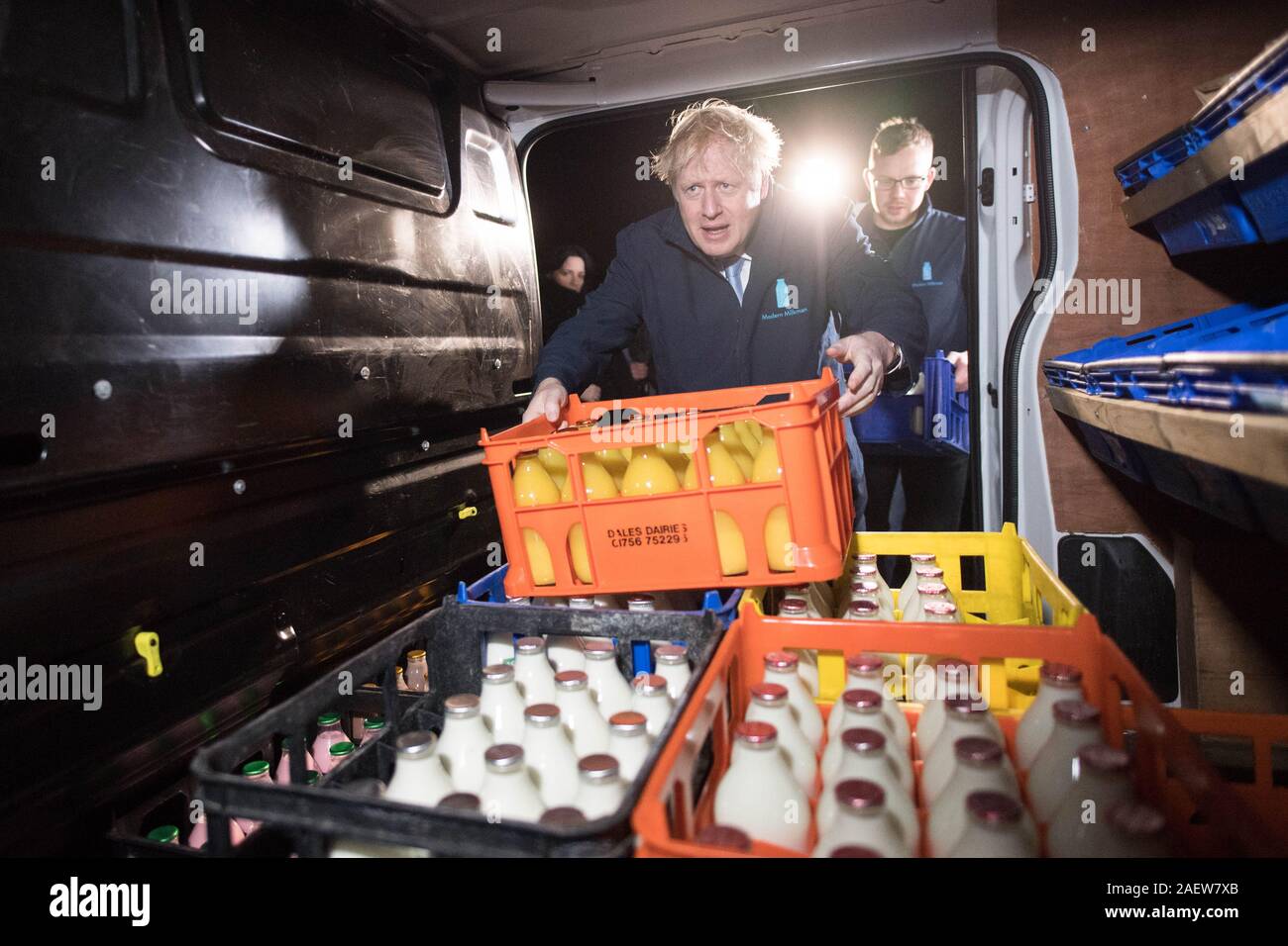 Il primo ministro Boris Johnson carichi di una cassa in un furgone durante una visita a Greenside Farm Business Park di Leeds, davanti a giovedì l'elezione generale. Foto Stock