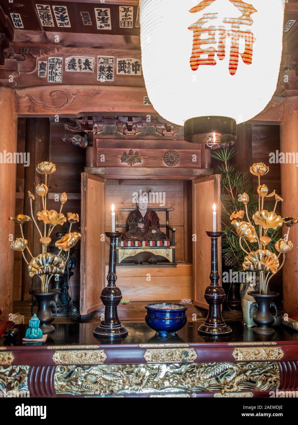 Altare con Kobo Daishi Kukai statua, candele accese, chochin lanterna, tempio Meisekiji 43, 88 Tempio pellegrinaggio di Shikoku, Ehime Shikoku Giappone Foto Stock