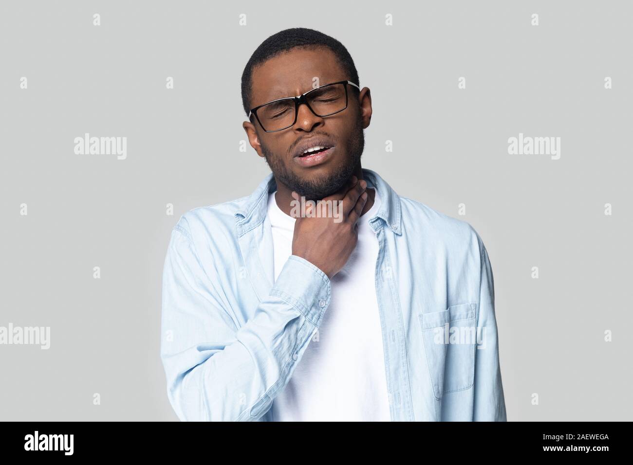 Studio colpo alla testa giovane americano africano guy che soffrono di angina. Foto Stock