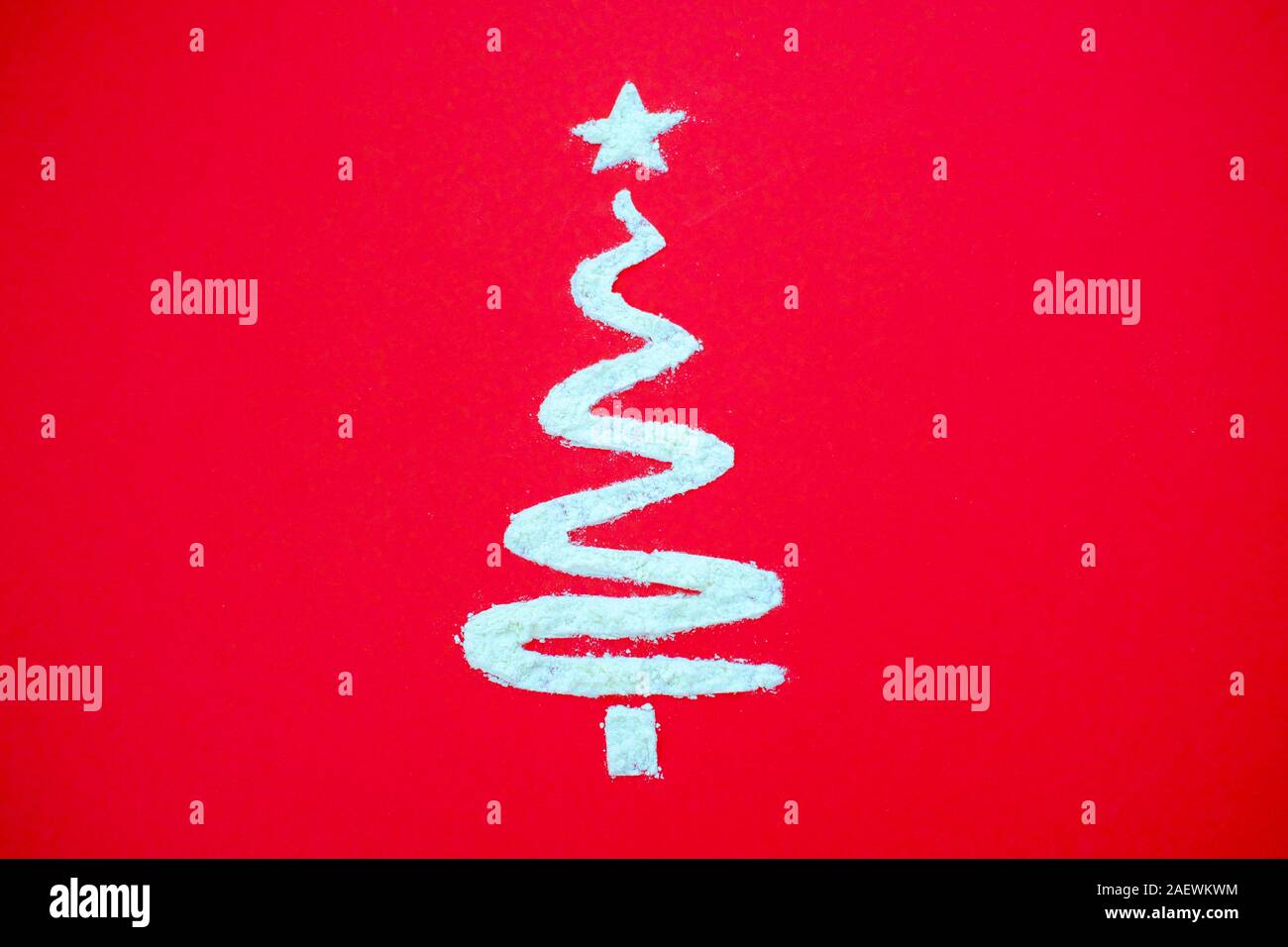 Albero di Natale fatto di farina bianca su sfondo rosso. Panificio di natale e la cucina creativa concetto minimale. Laici flat top view composizione. Copyspace. Foto Stock
