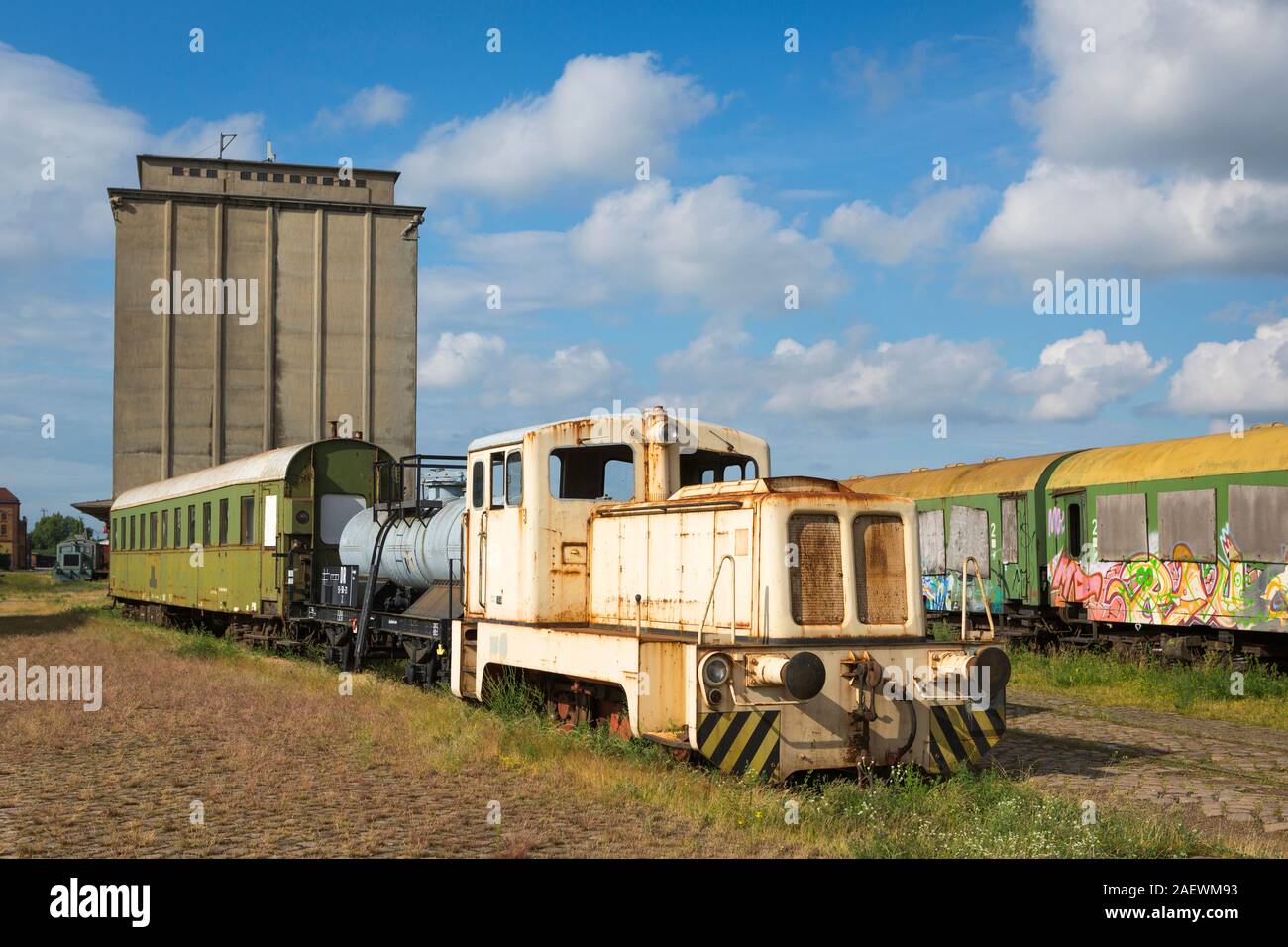 Locomotiva Vintage passeggero e i carri con graffiti per la riparazione in posizione abbandonata, di Magdeburgo, Germania Foto Stock