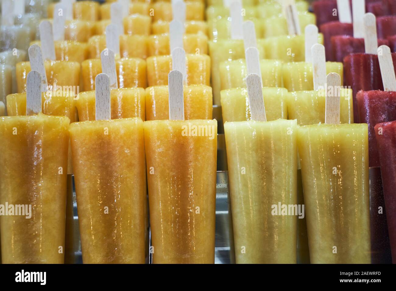 Naturali freschi di Puro succo di frutta aromatizzato ghiaccioli su bastoni di legno per la vendita in un contatore di freezer - gelato - ice popsicles - ice pops - aromi Foto Stock