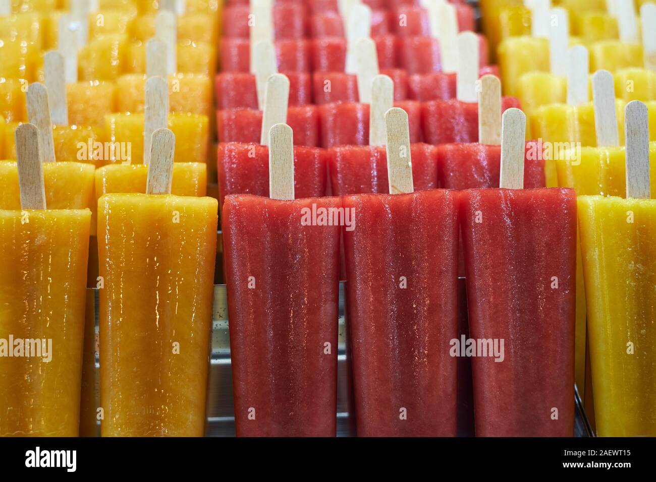 Naturali freschi di Puro succo di frutta aromatizzato ghiaccioli su bastoni di legno per la vendita in un contatore di freezer - gelato - ice popsicles - ice pops - aromi Foto Stock