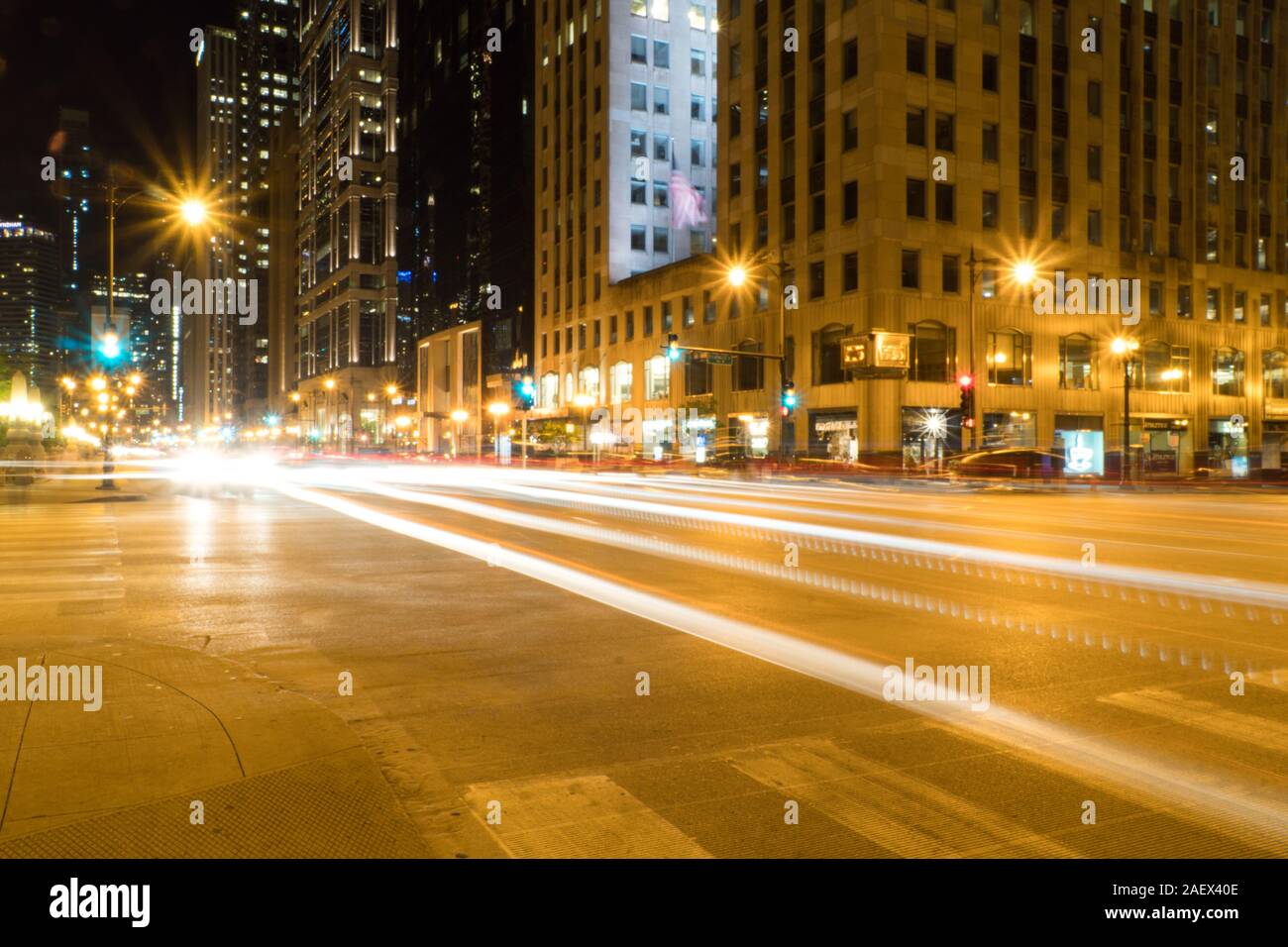 Tempo di notte lunga esposizione della trafficata strada urbana modo guidando attraverso città urbana area grattacieli del passato il centro con percorsi di luce di attraversamento di automobili si intersecano Foto Stock