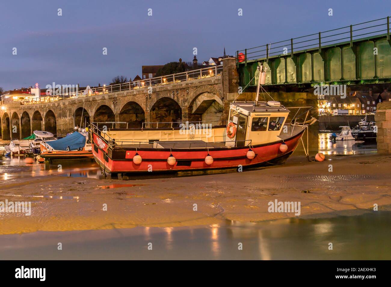 Barca da pesca bloccato sul fango con la bassa marea a Folkstone il porto interno. Prese la sera utilizzando exsposure lungo il 7 Dic 2019. Folkstone, Kent, U Foto Stock