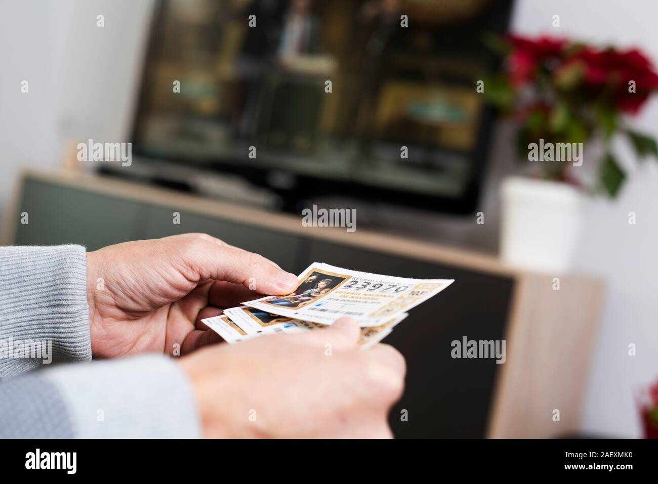 Barcellona, Spagna - DESEMBER 11, 2019: primo piano di un uomo con alcuni biglietti della spagnola lotteria di Natale in mano mentre si sta guardando il televisiva Foto Stock