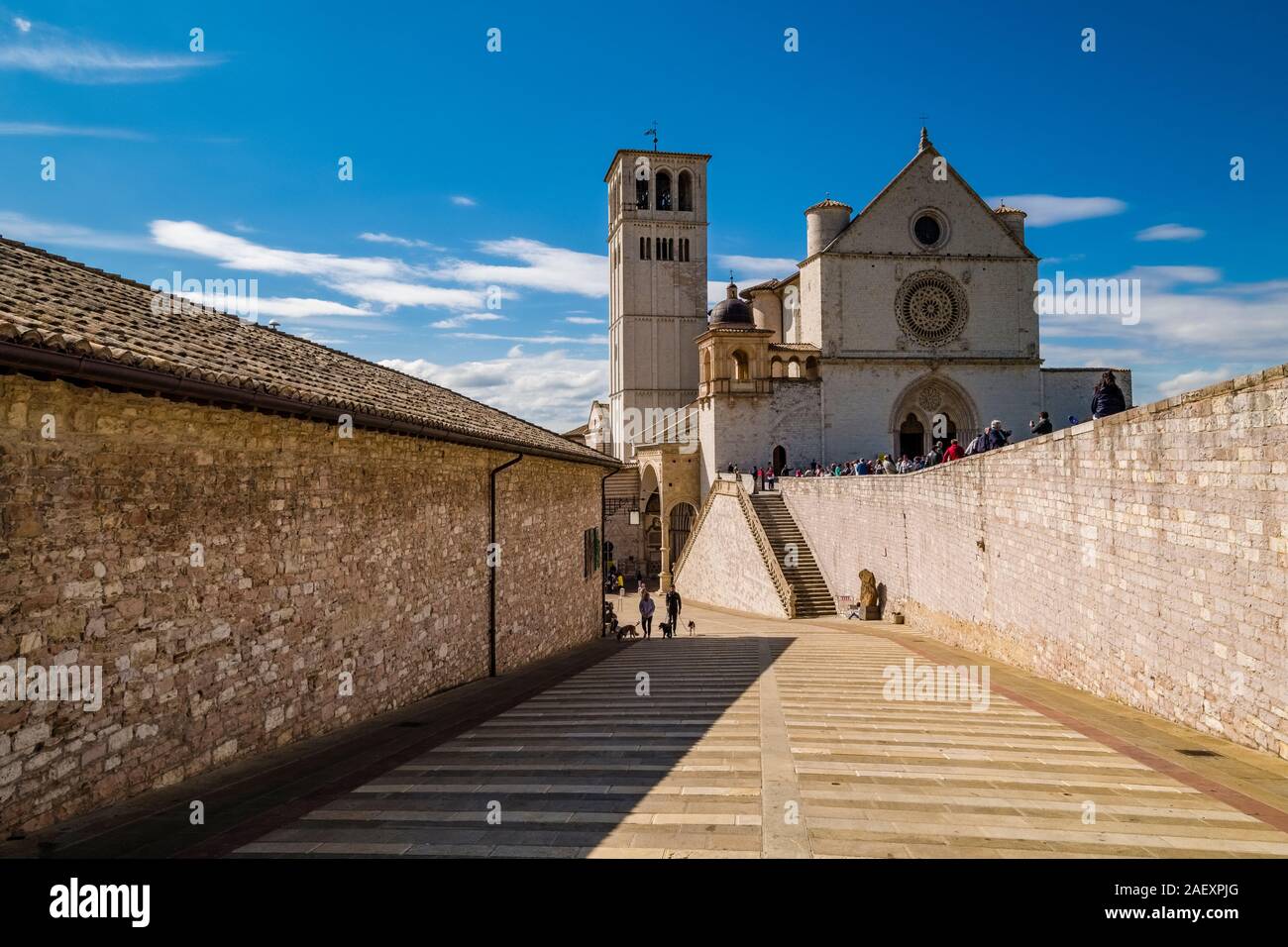 Basilica di San Francesco di Assisi alla fine di un vicolo largo tra muri di pietra Foto Stock