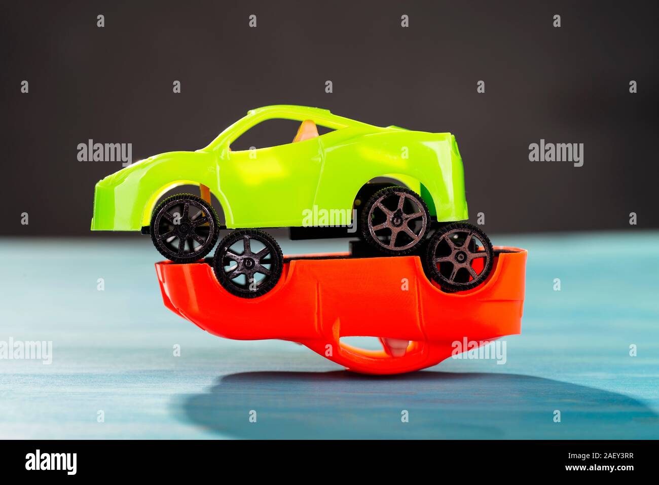 Un verde è in piedi su un auto rossa che è capovolto. Foto Stock