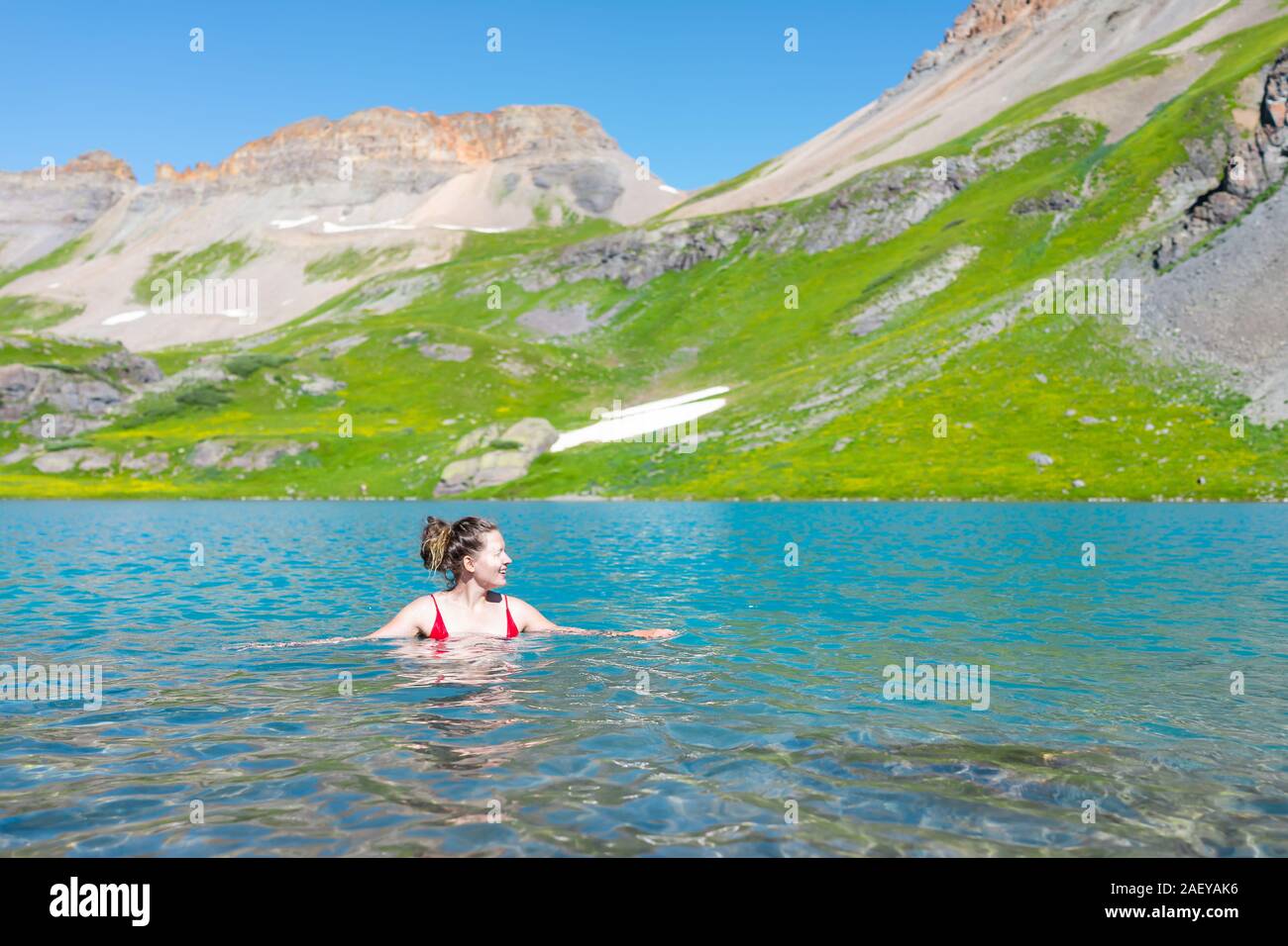 Giovane donna felice ragazza nuotare nella vibrante fredda acqua del lago di ghiaccio sul famoso sentiero in Silverton, Colorado in San Juan Mountains in estate Foto Stock