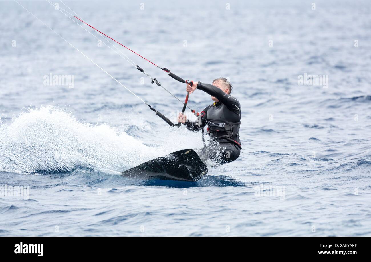 Un kite surfer provare a cavalcare le onde Foto Stock