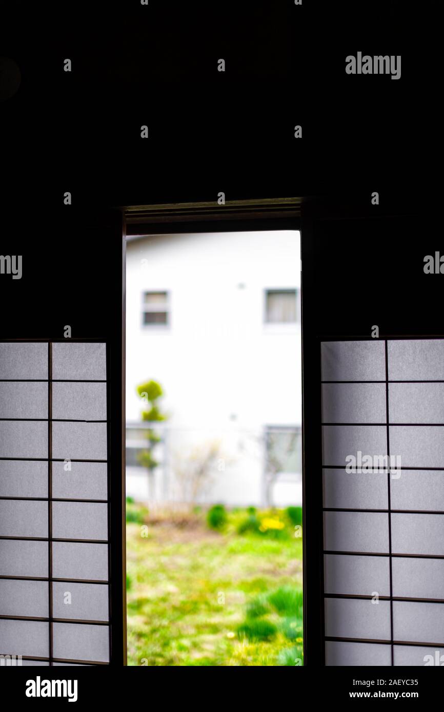 Tradizionale casa giapponese casa o ryokan hotel in Giappone con il primo piano di aprire porte scorrevoli di carta shoji al giardino verde Foto Stock