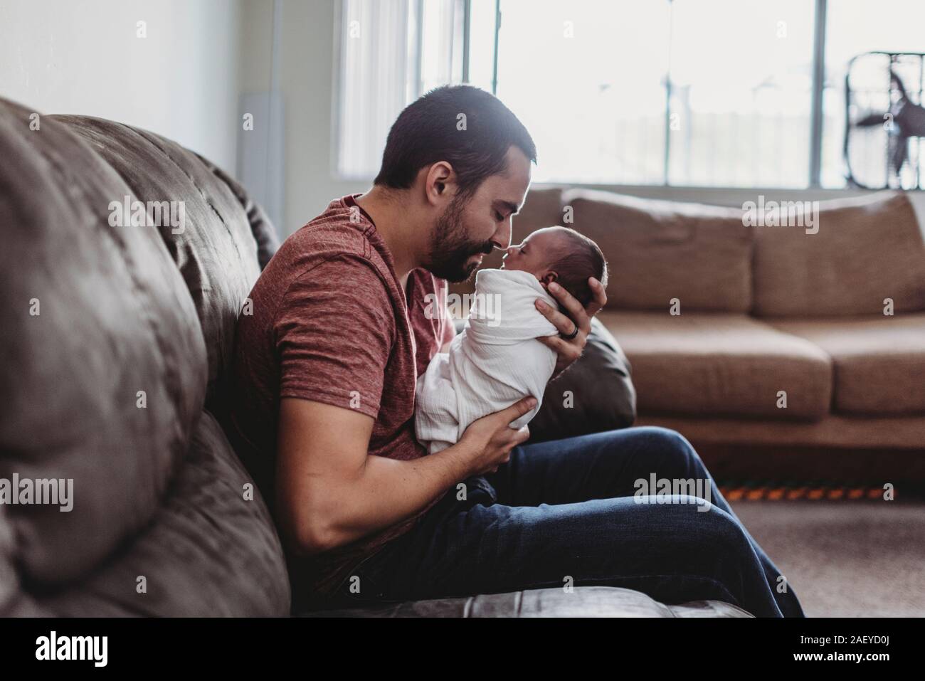 Padre barbuto il legame con il neonato avvolto in coltre bianca Foto Stock