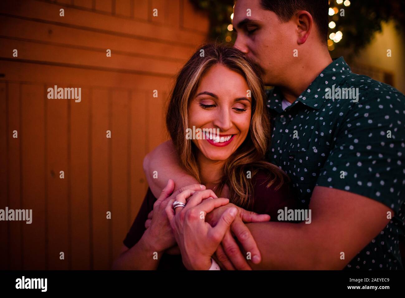 Il marito abbraccia la moglie come sorride Foto Stock