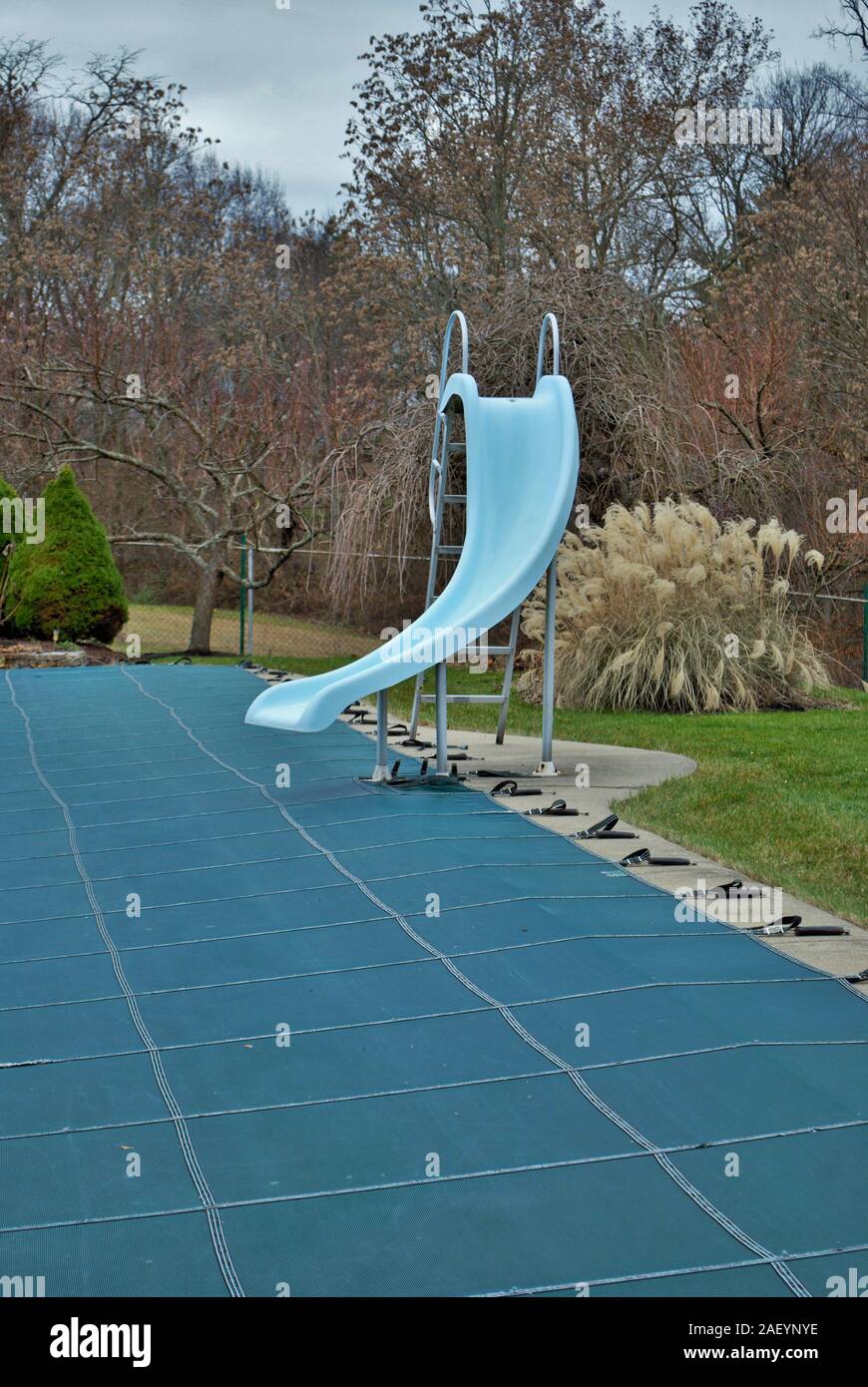 Backyard piscina con trampolino e piscina tarped slide up e chiuso per l'inverno Foto Stock