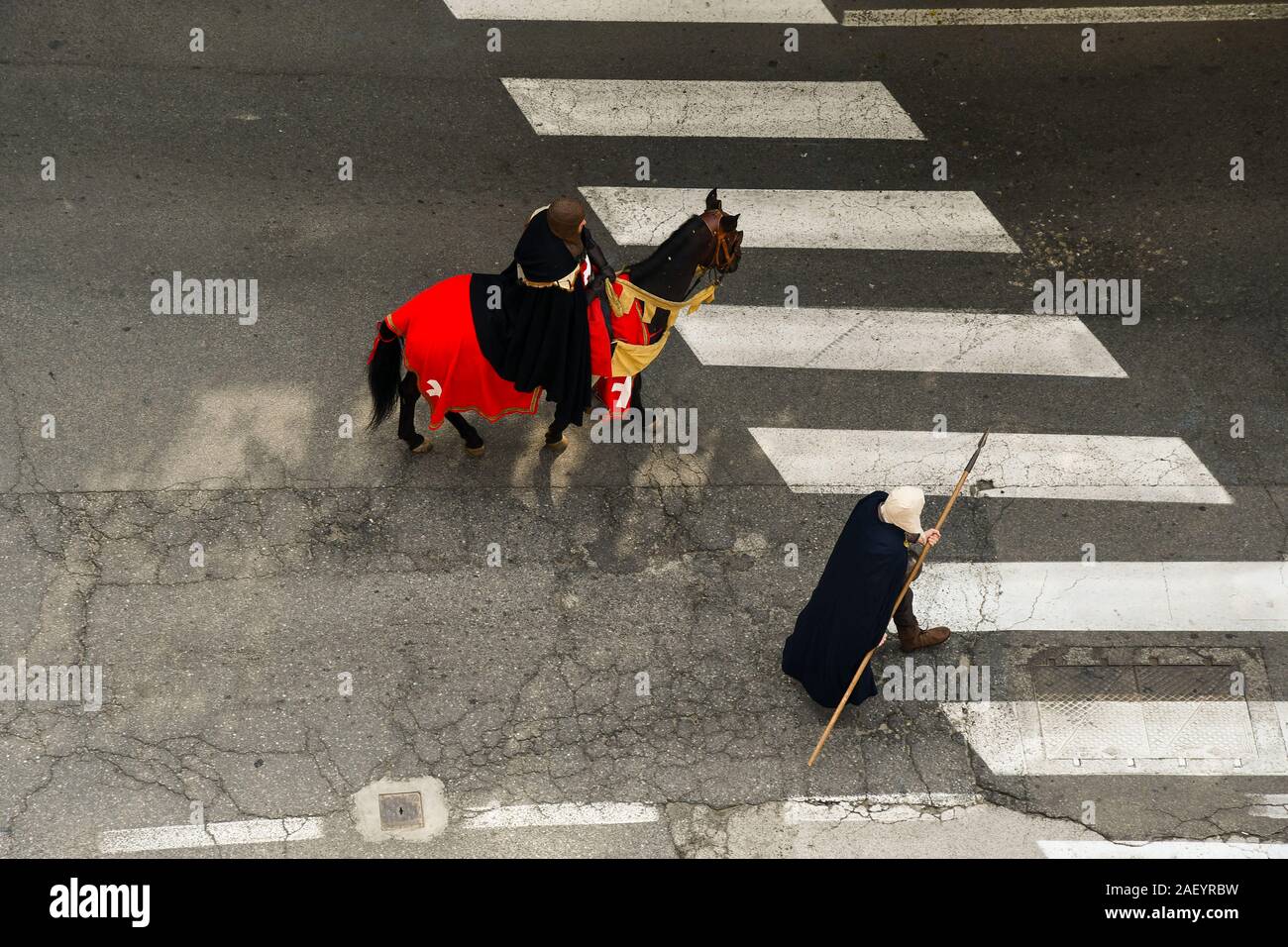 Vista in elevazione di due uomini in costume medievale e una imbrigliato cavallo durante la sfilata del corteo storico del bianco di Alba Fiera del Tartufo, Cuneo, Piemonte, Italia Foto Stock