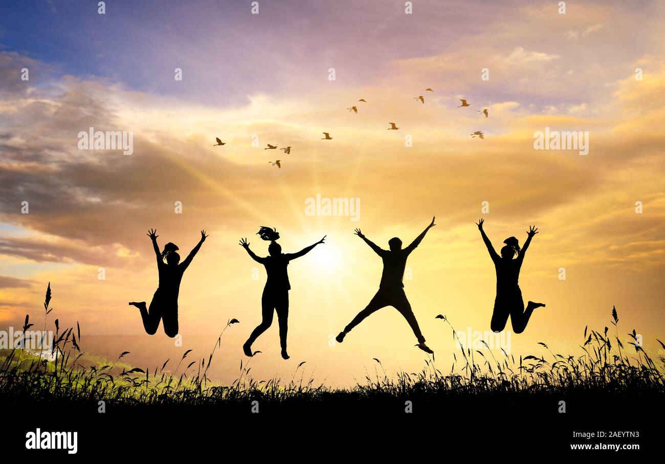 Un gruppo di ragazzi adolescenti stanno saltando e divertirsi durante l'impostazione sun. Angolo retroilluminato Foto Stock