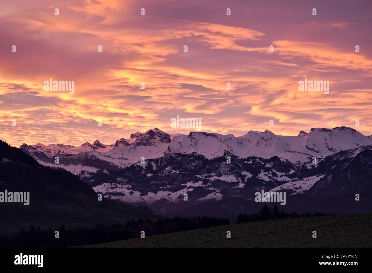 Alpi svizzere vicino a Lucerna, Svizzera, coperto di neve durante una splendida alba con il cielo sul fuoco. Foto Stock