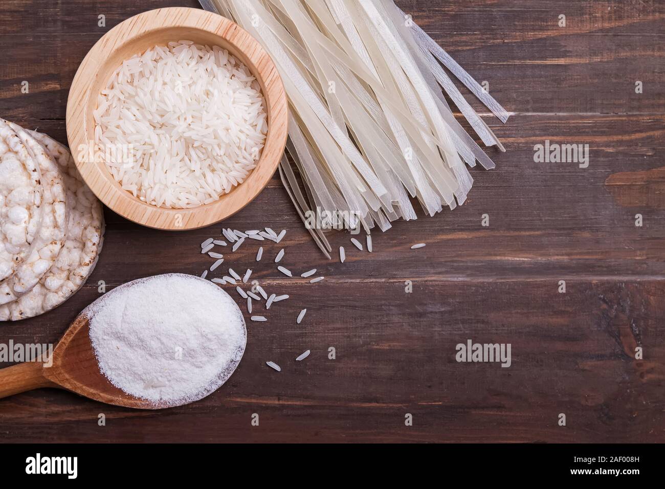 Prodotti a base di riso su un tavolo di legno, vista dall'alto. Senza glutine a base di noodle, la farina, il grano e cracker. Foto Stock