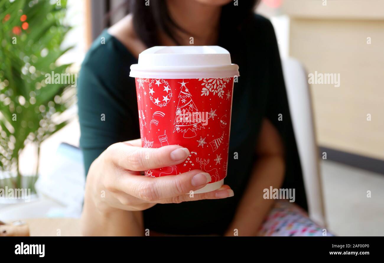 Donna che mantiene un rosso e bianco Natale foglio di modello Tazza da caffè Foto Stock