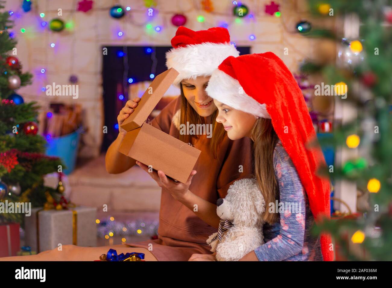 La mamma e la ragazza ha aperto il dono coperchio e sbirciato nella scatola Foto Stock