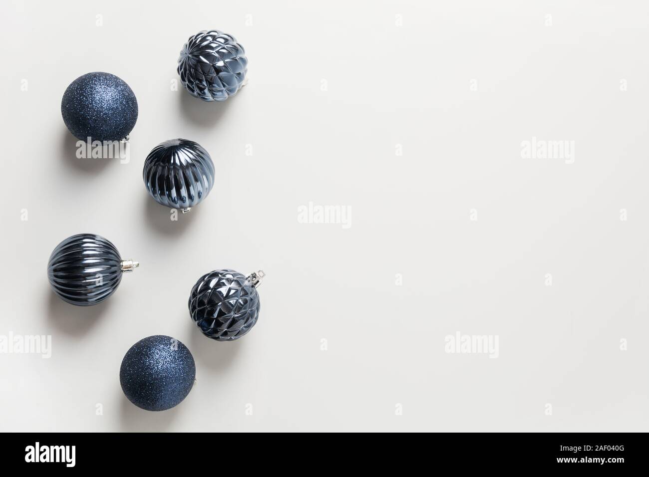 Il Natale di blu classico palle su neutro grigio pastello. Vista dall'alto. Xmas. Messaggio di saluto festivo card. Colore alla moda del 2020 Anno. Foto Stock