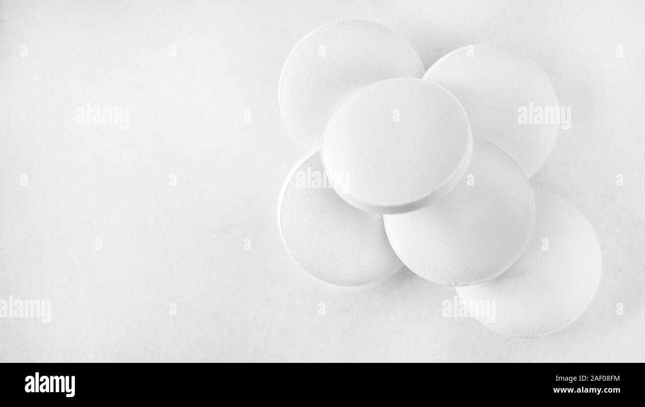 Bianco pillole di analgesico su marmo bianco sullo sfondo Foto Stock